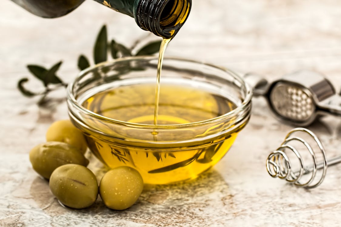 Botella de aceite de oliva virgen extra con aceitunas